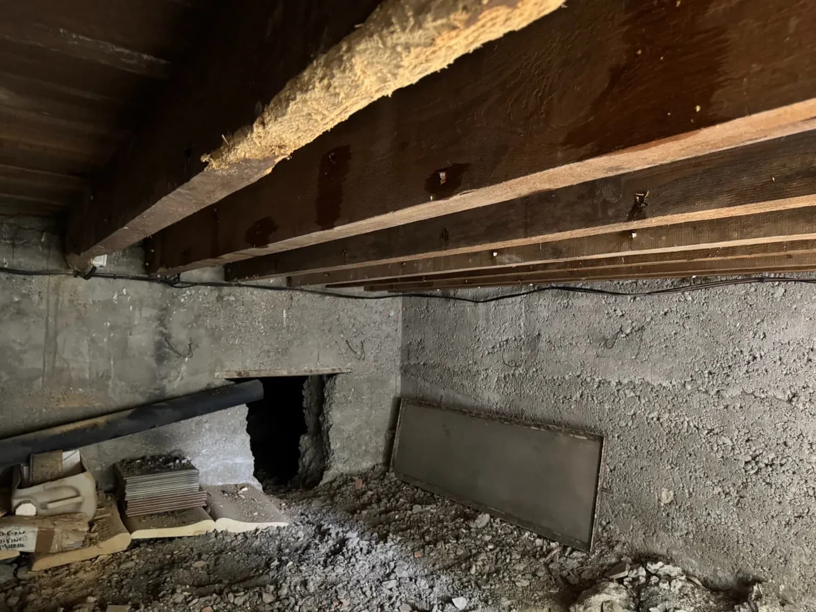 Vue d'ensemble du vide sanitaire d'une maison de Blanquefort avec solives et maçonnerie humides
