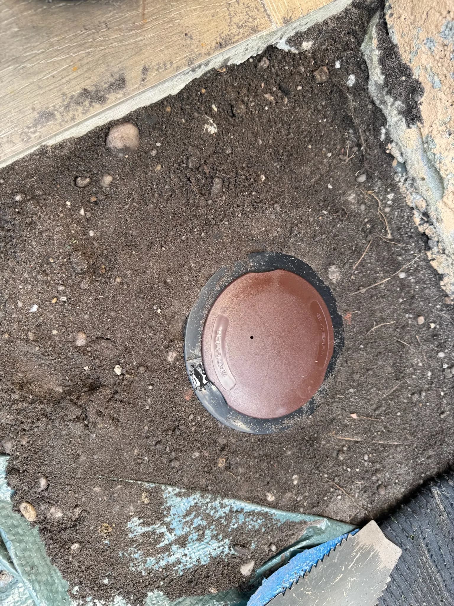 Station d'appâtage Exterra™ enterrée en cours d'installation dans le sol à Eysines