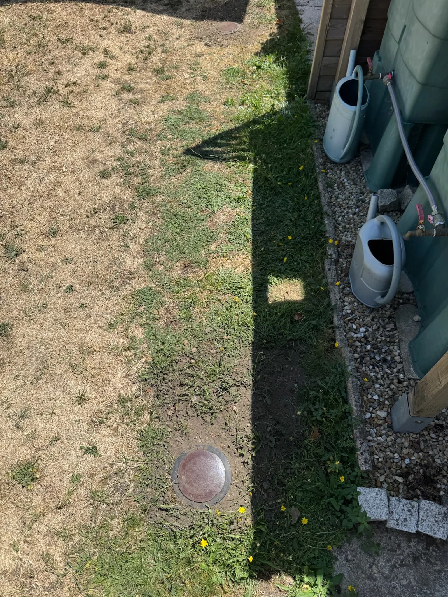 Capot d'une station d'appâtage anti-termites à fleur de terre dans un jardin à Ambarès-et-Lagrave