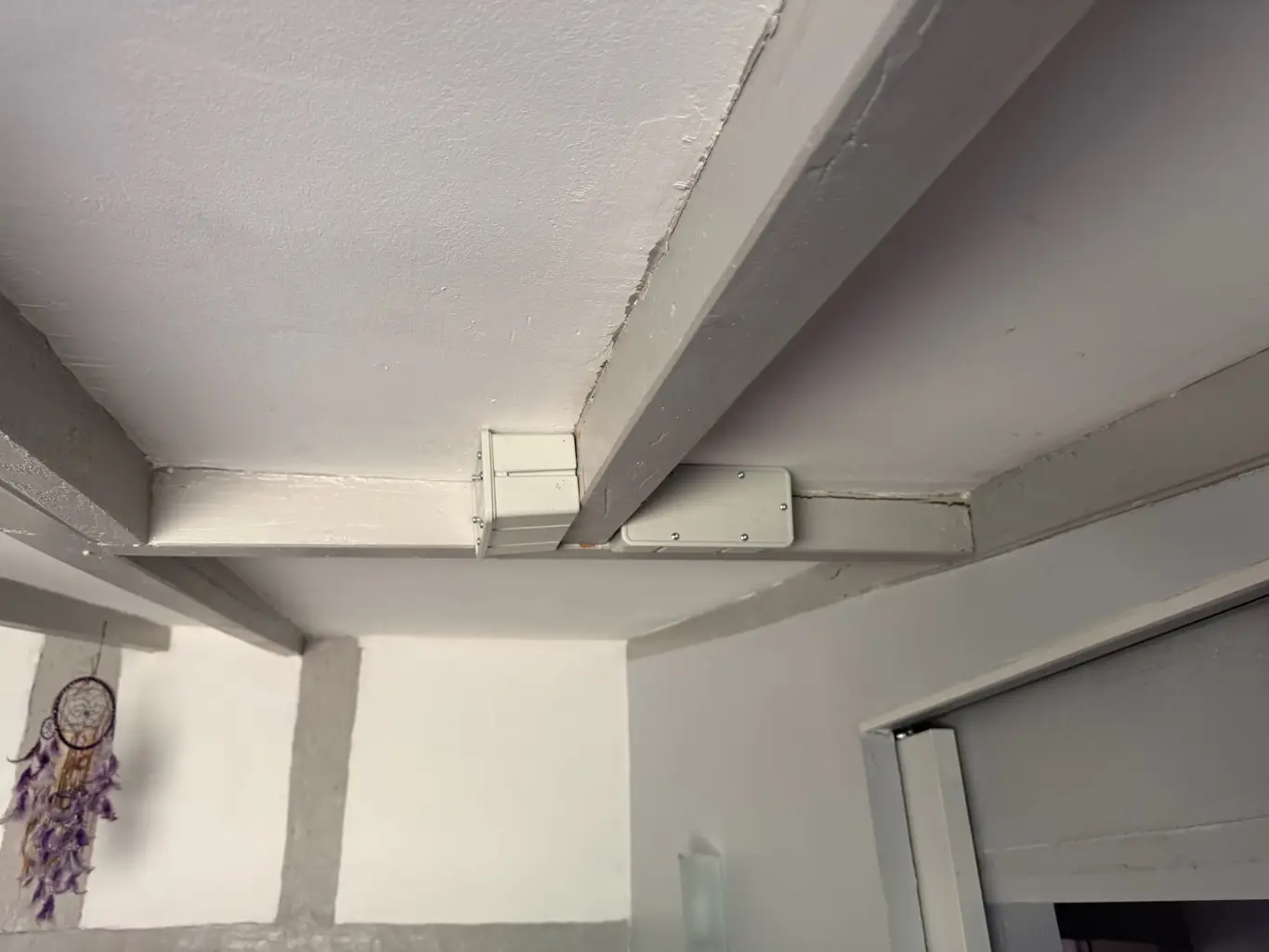 Station d'appâtage intérieure posée sur une poutre pour traiter les termites à Louchats