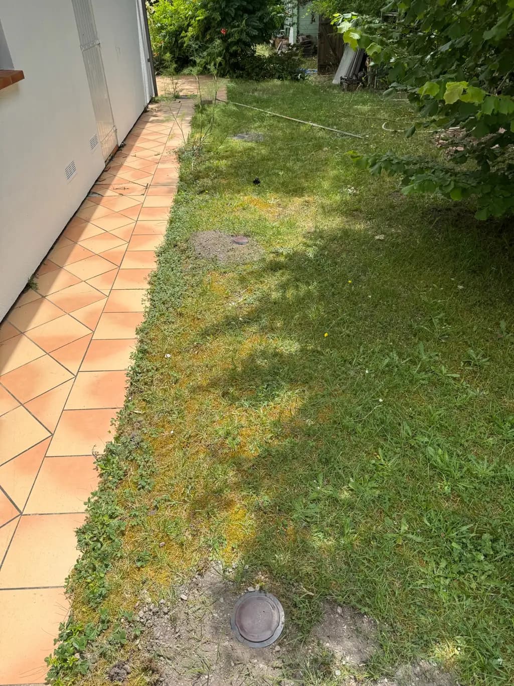 Stations d'appâtage anti-termites réparties dans le jardin en périmètre d'une maison à Pessac
