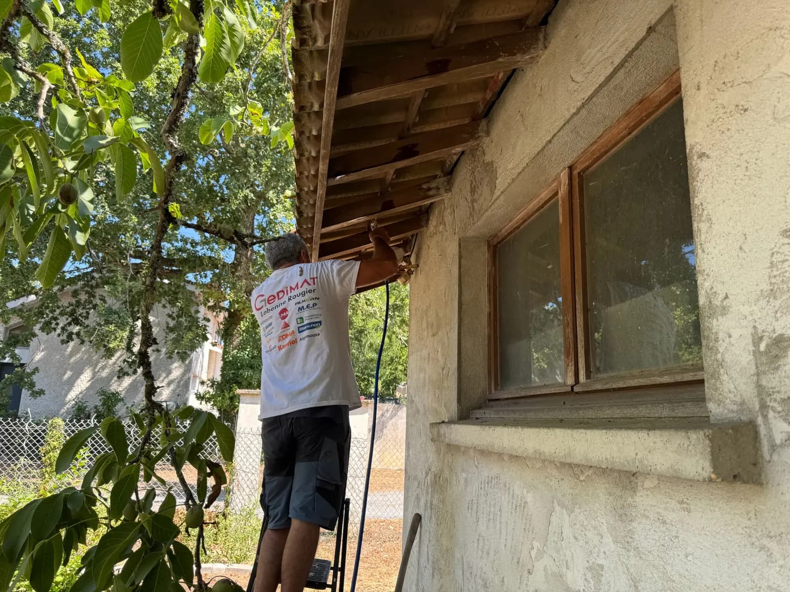 Technicien traitant le débord de toit d'une maison au pulvérisateur à Saint-Médard-en-Jalles