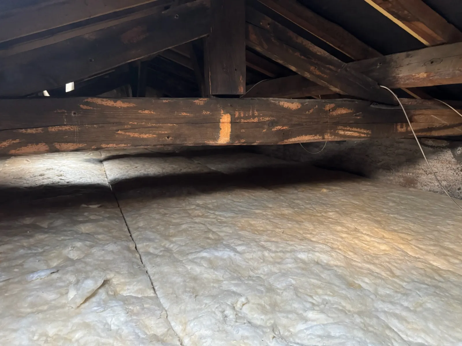 Combles ré-isolés avec une nouvelle laine minérale sous une charpente traitée à Belin-Béliet